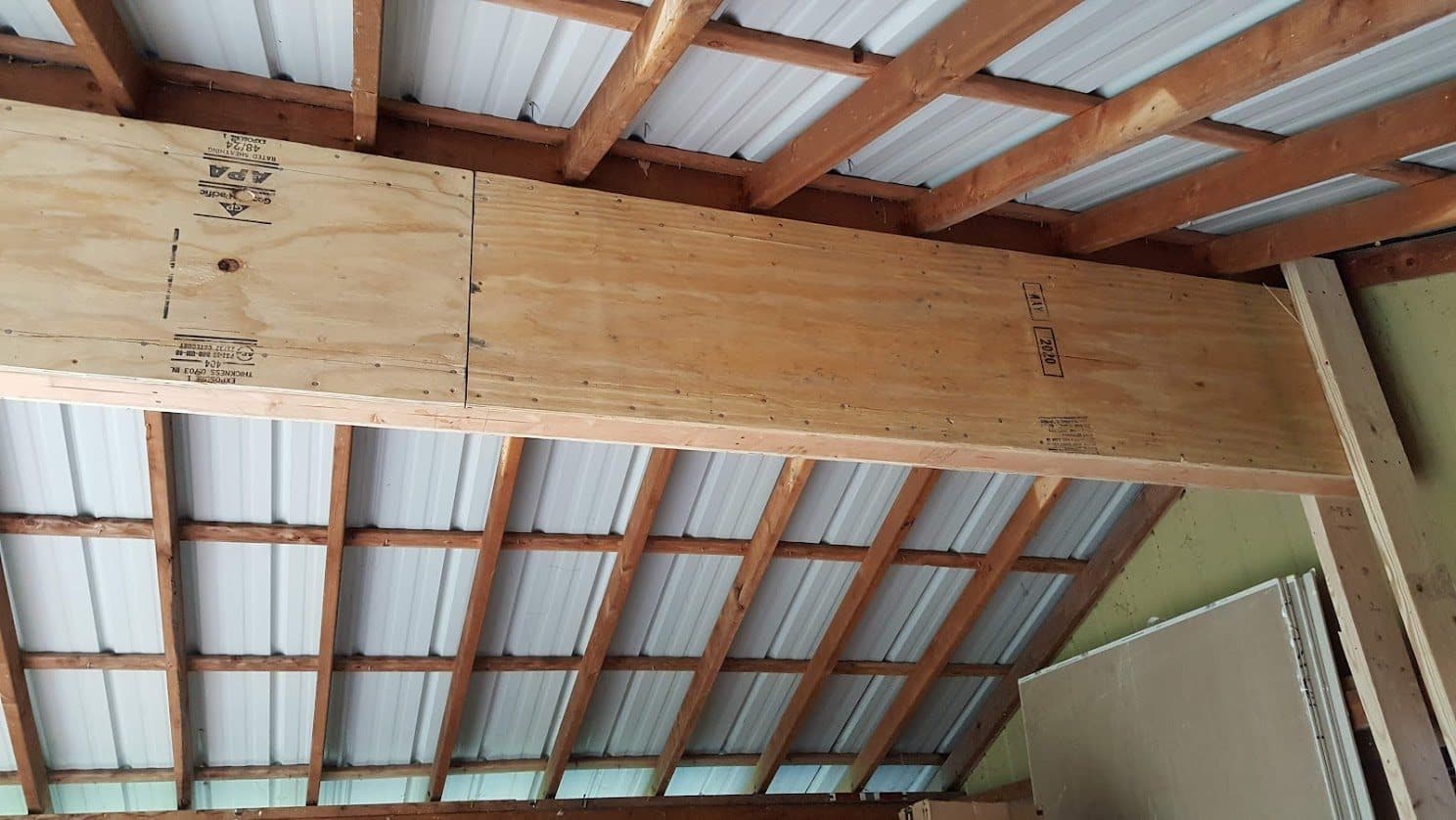 The structural box beam spanning a wide opening, sheathed in rated structural plywood