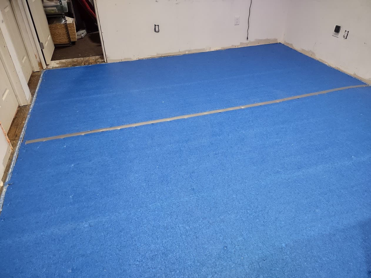 New carpet cushion laid over the subfloor with the pad seam taped down the middle