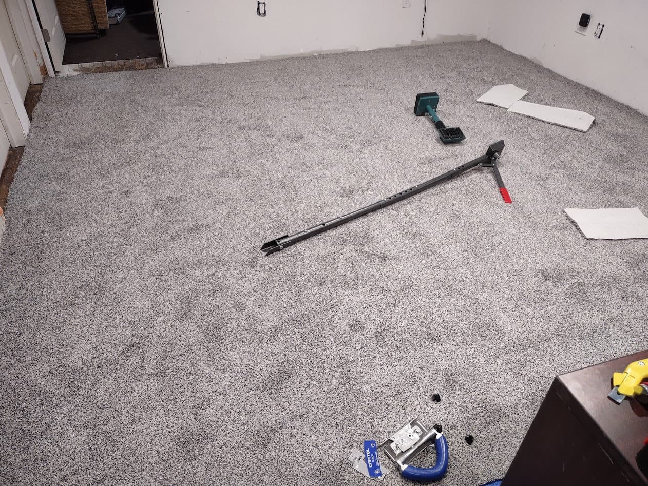 The gray carpet rolled out and power-stretched tight to the tackless strips