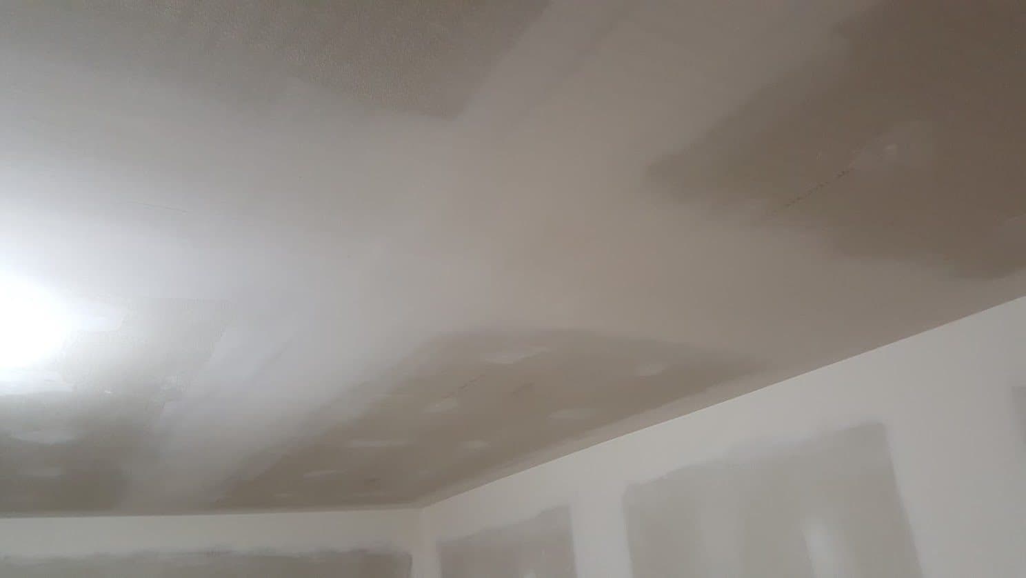 Drywall ceiling skim-coated and feathered out where it meets the wall