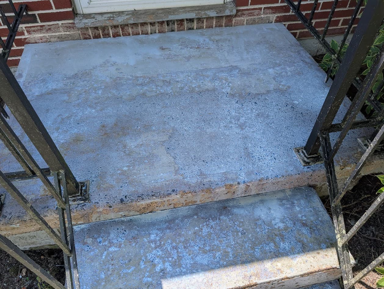The cleaned stoop landing after washing, the old finish removed and the bare concrete prepped before repainting